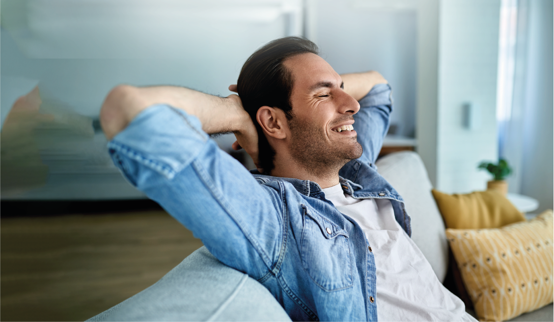 A relaxed individual enjoying the peace of mind that comes with tailored financial solutions from Banco Hipotecario, set in a modern, well-lit minimalist space.